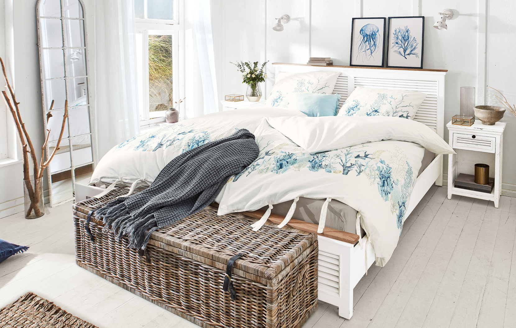 Slaapkamer in maritieme stijl met wit bed en beddengoed met blauw zeeplanten- en dierenmotief