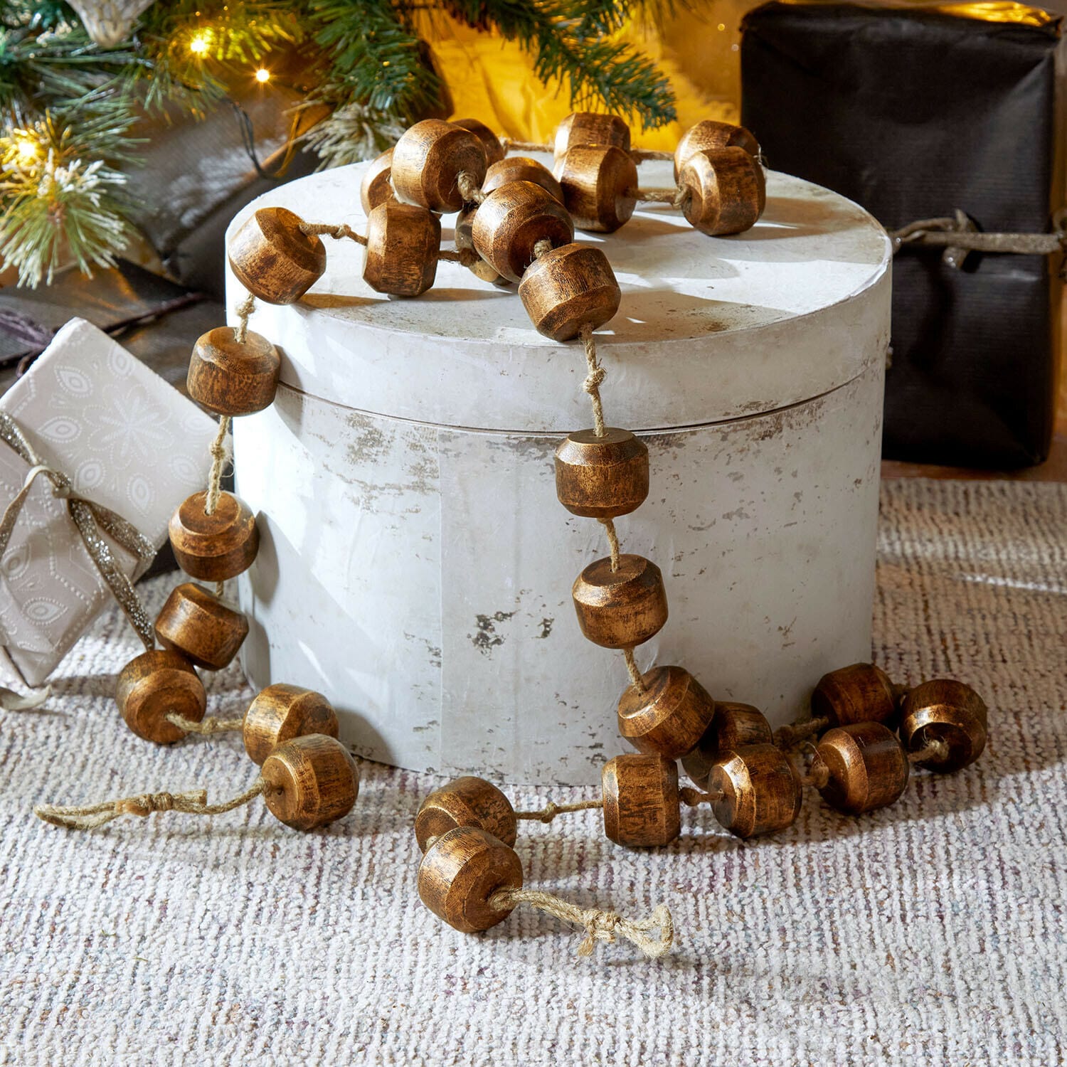 Guirlande Caralinas Decoratieve ketting van bruine houten kralen op lichte ondergrond, feestelijke kerstversiering