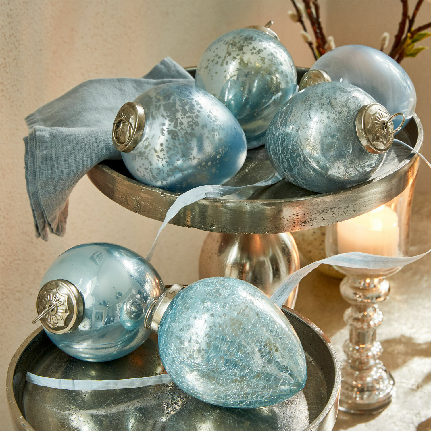 Paasei set van 6 Cataleya Set blauwe glazen kerstballen met metalen ophangingen op een zilveren decoratieve schaal