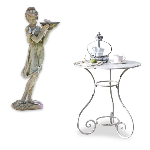 Groene decoratieve vrouwenfiguur met dienblad naast witte metalen bijzettafel met kopjes en dienblad