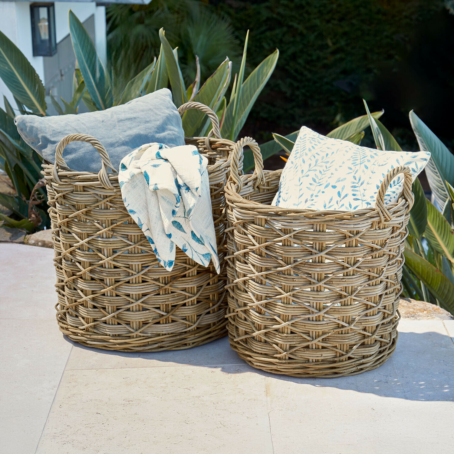Twee natuurlijke rieten manden met kussens en deken, buitendecoratie voor tuin