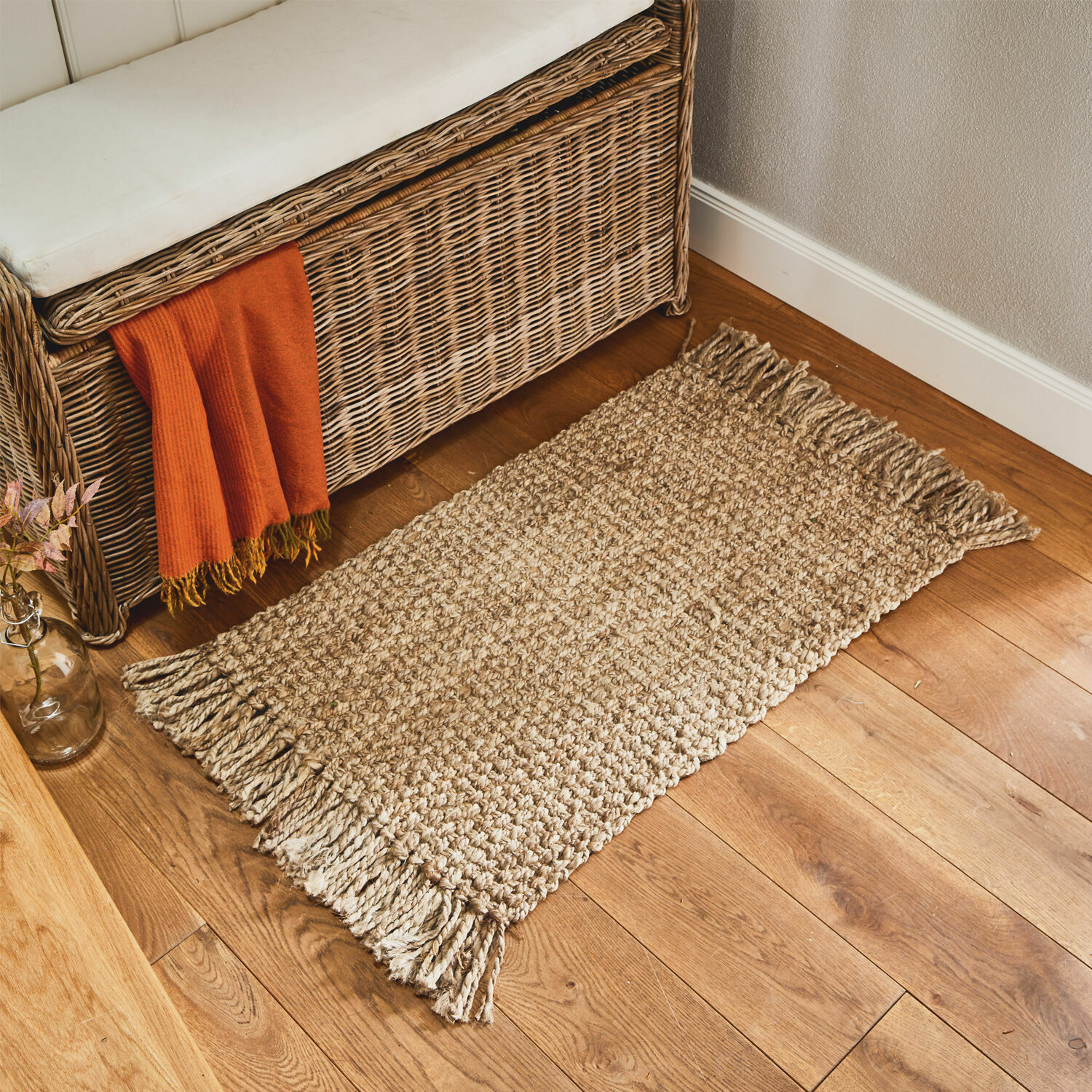 Deurmat Moody Beige vloerkleed met franjes van natuurlijk materiaal op houten vloer in gezellige ruimte