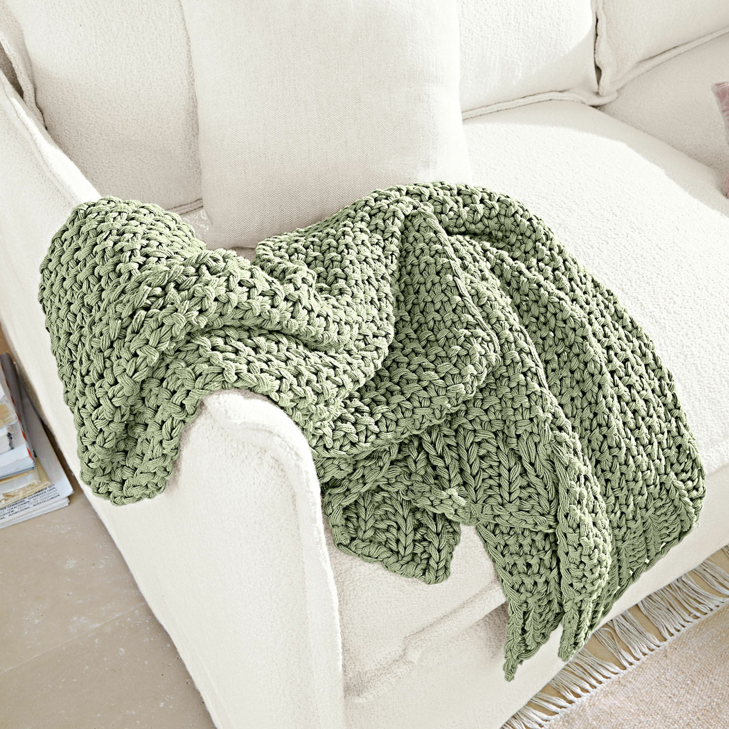 Plaid Plixoren Zachte groene grofgebreide deken op witte bank, sfeervolle en comfortabele woondecoratie
