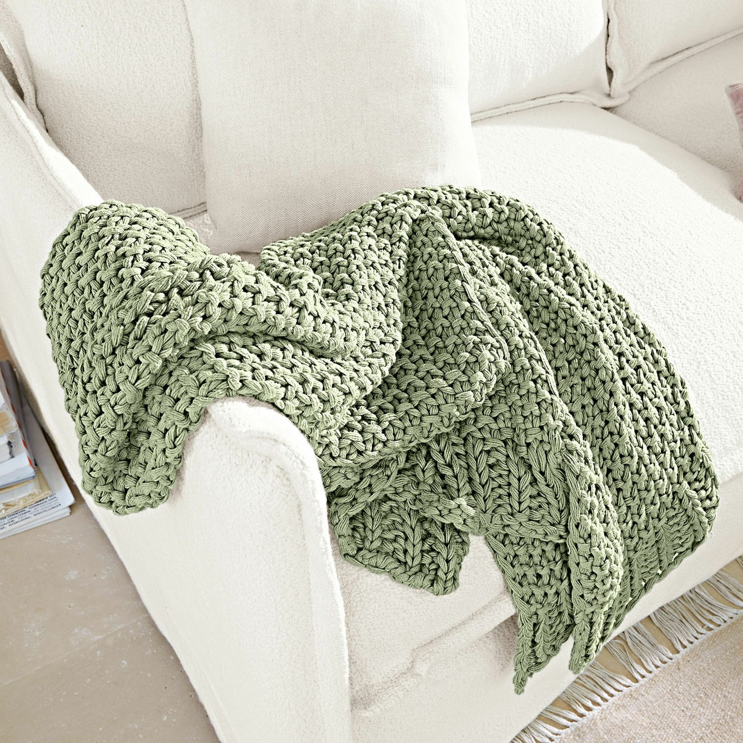 Plaid Plixoren Zachte groene grofgebreide deken op witte bank, sfeervolle en comfortabele woondecoratie