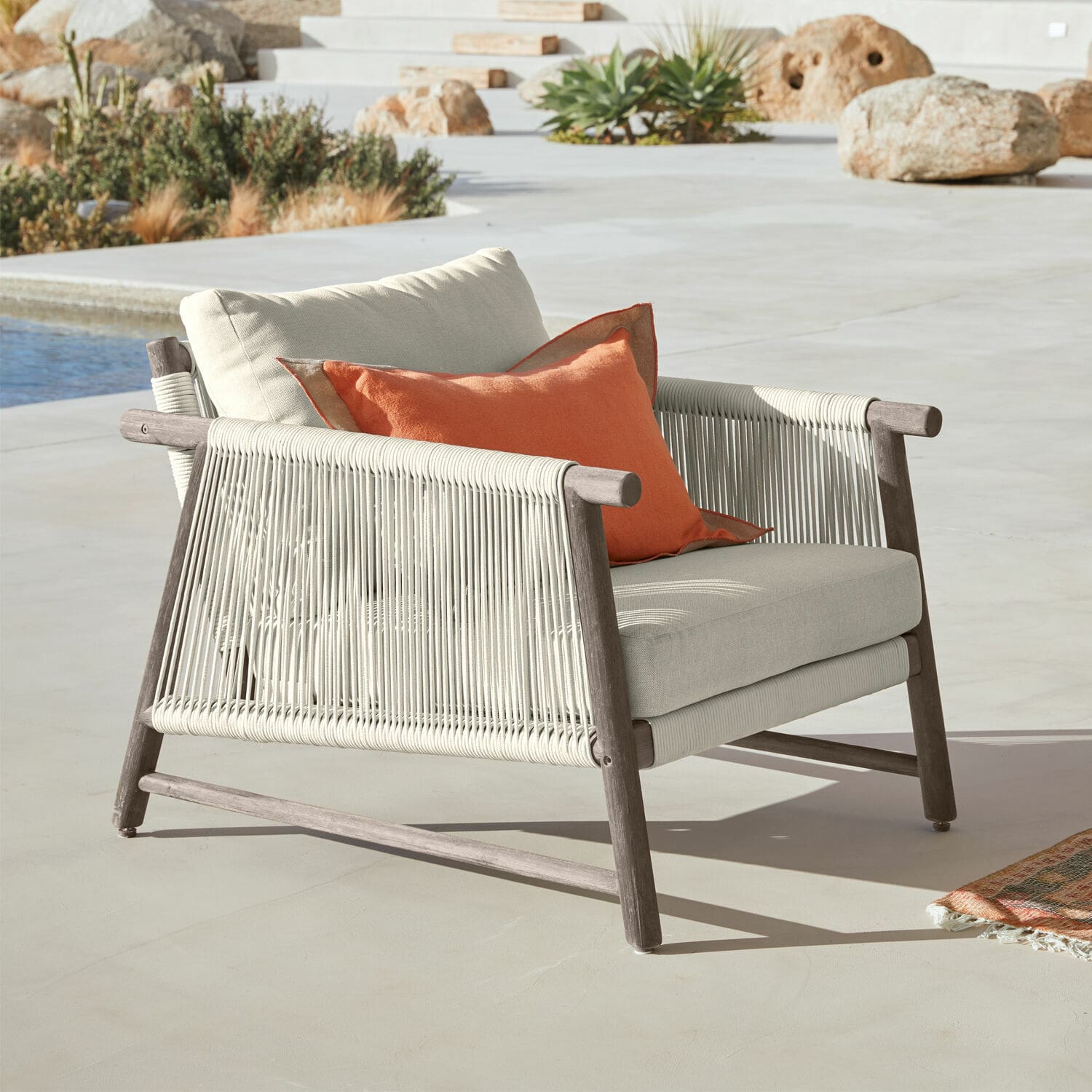 Leunstoel FSC®-100% Clarmontaine Buitenstoel van hout en beige touw met oranje kussen, terrasmeubilair