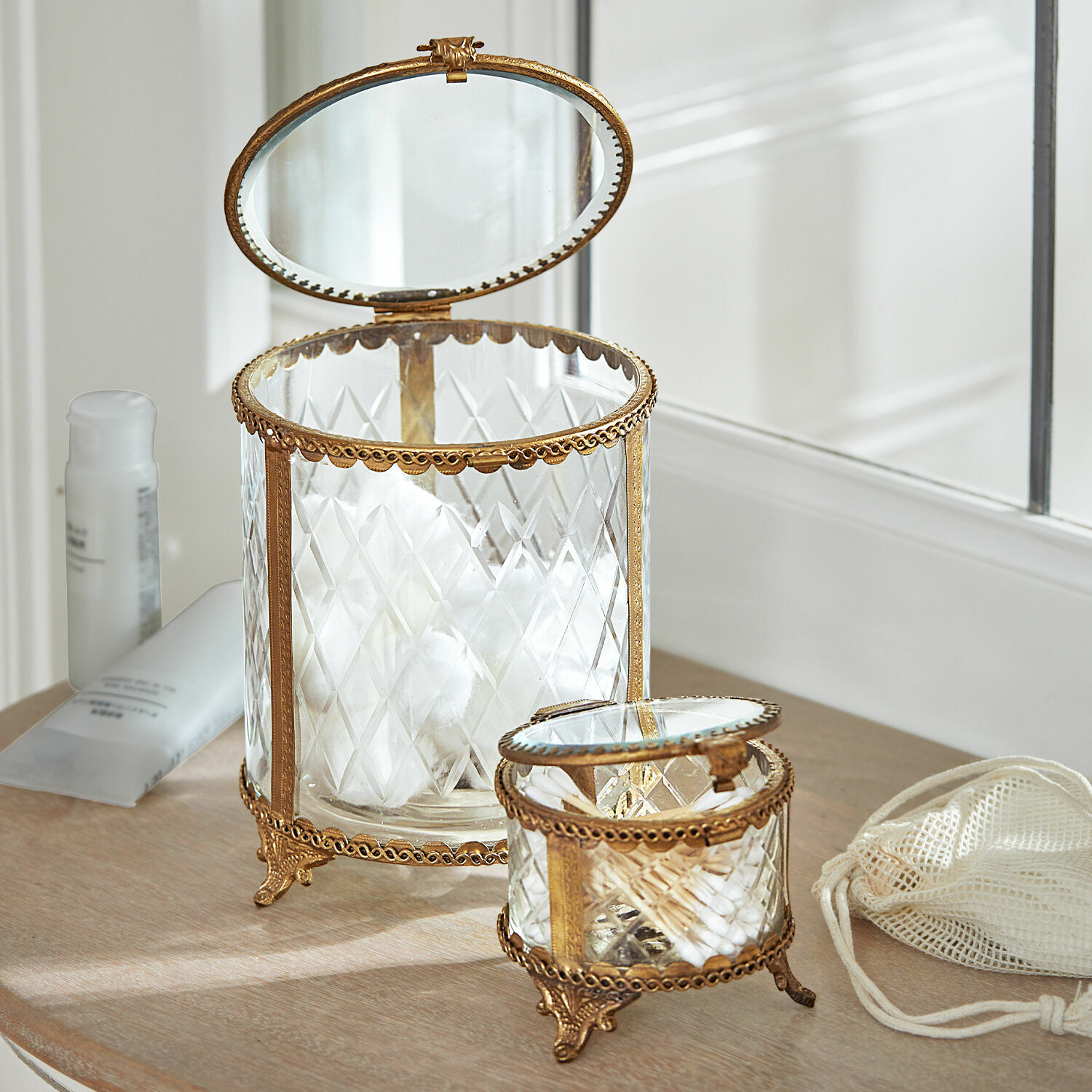 Glazen potten met messing frame en deksel voor watten en wattenstaafjes in badkamer