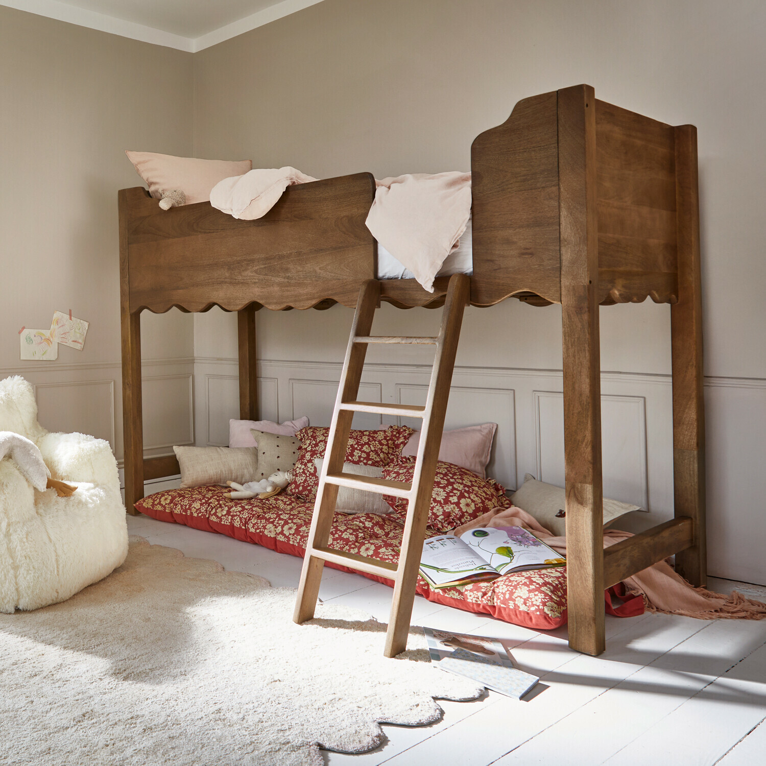 Bruin houten hoogslaper met ladder en zachte kussens eronder, lichte kinderkamer