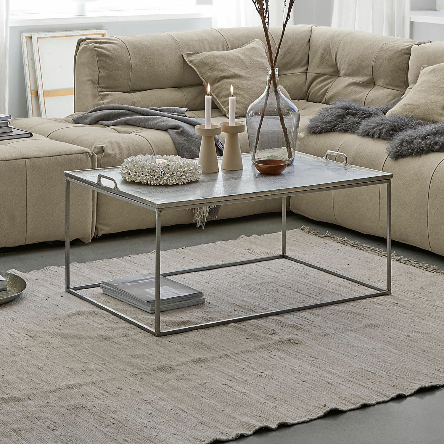 Salontafel Bellingham Moderne salontafel met metalen frame en zilverkleurig blad op beige vloerkleed in woonkamer