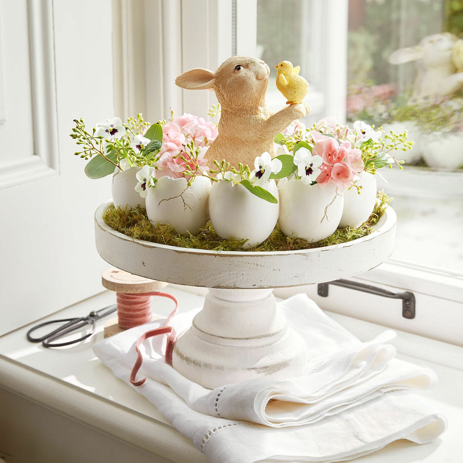 Etagère Loissard Paasdecoratie met keramische haas en bloemen in witte eierschalen op een houten standaard