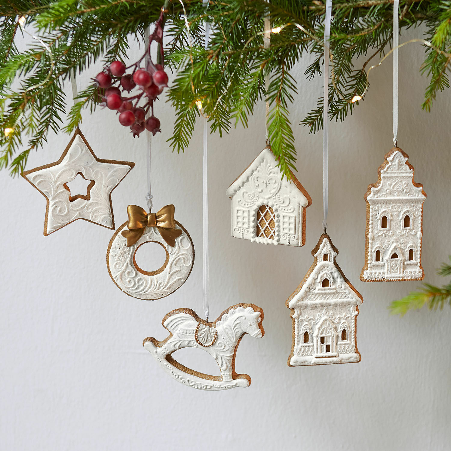 Set witte keramische kerstversieringen in ster-, huis- en hobbelpaardvorm om op te hangen