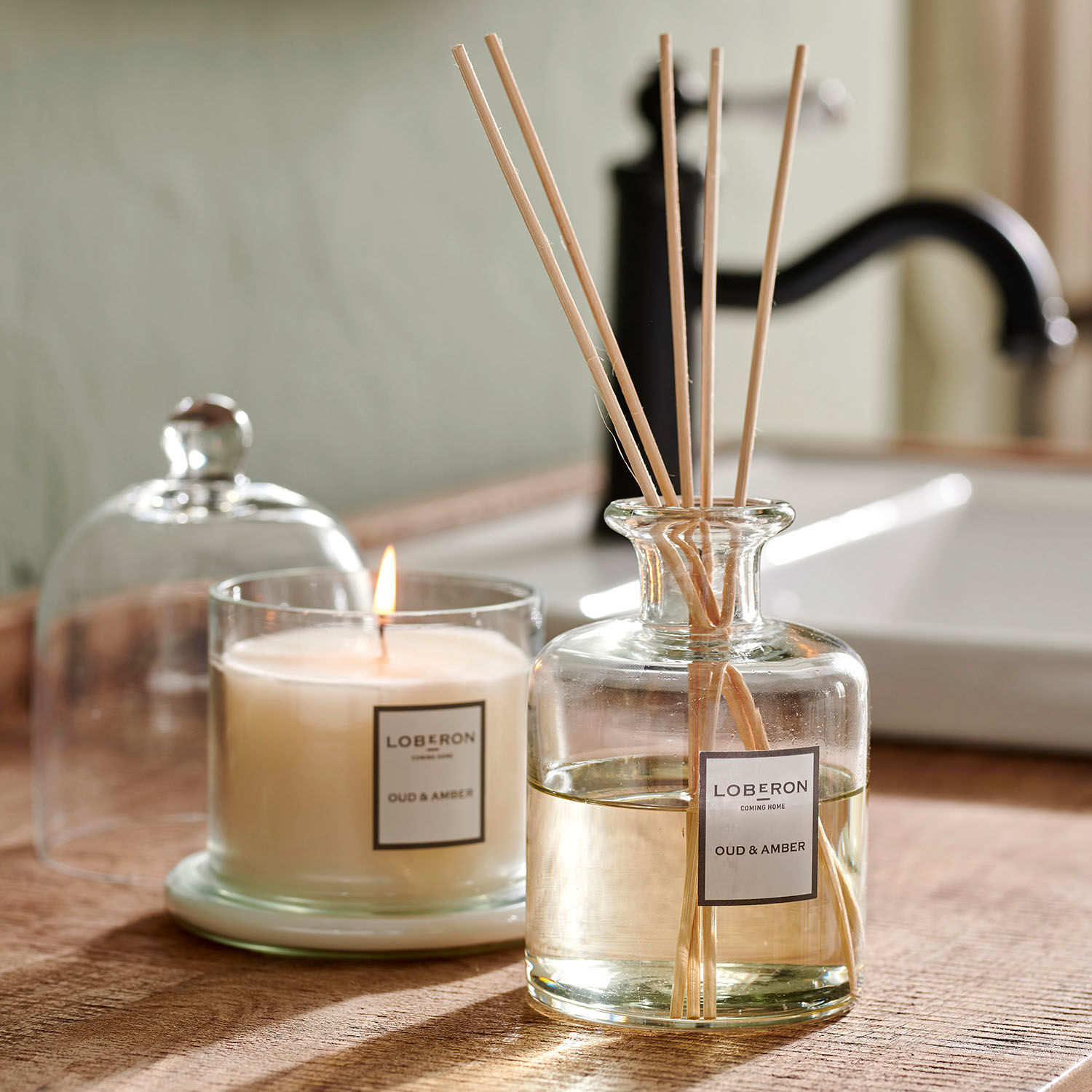 Geurset Vanis Glazen geurkaars en diffuser Oud & Amber op houten blad in badkamer