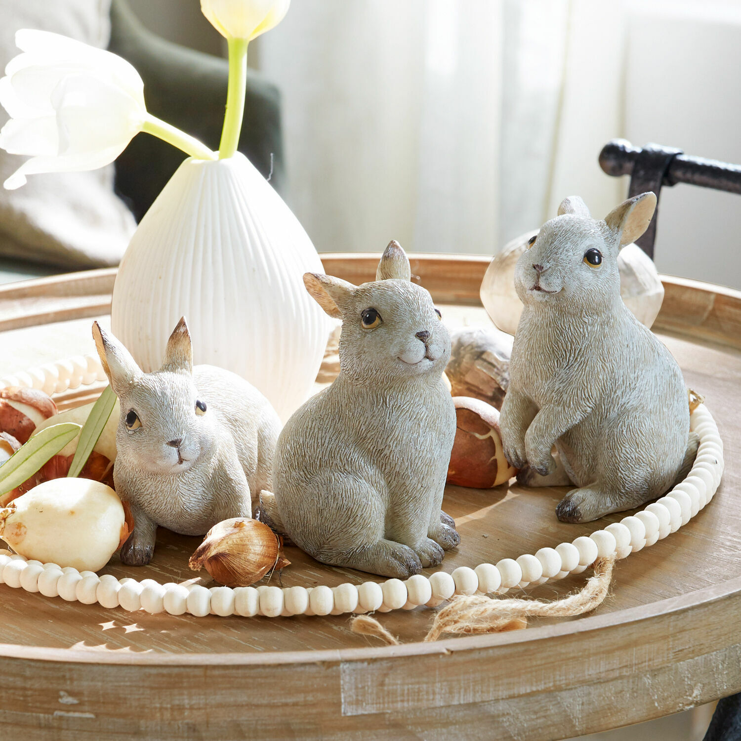 Haasje set van 3 Anthony Drie grijze konijnenfiguren op een houten dienblad met een witte vaas en bloembolletjes