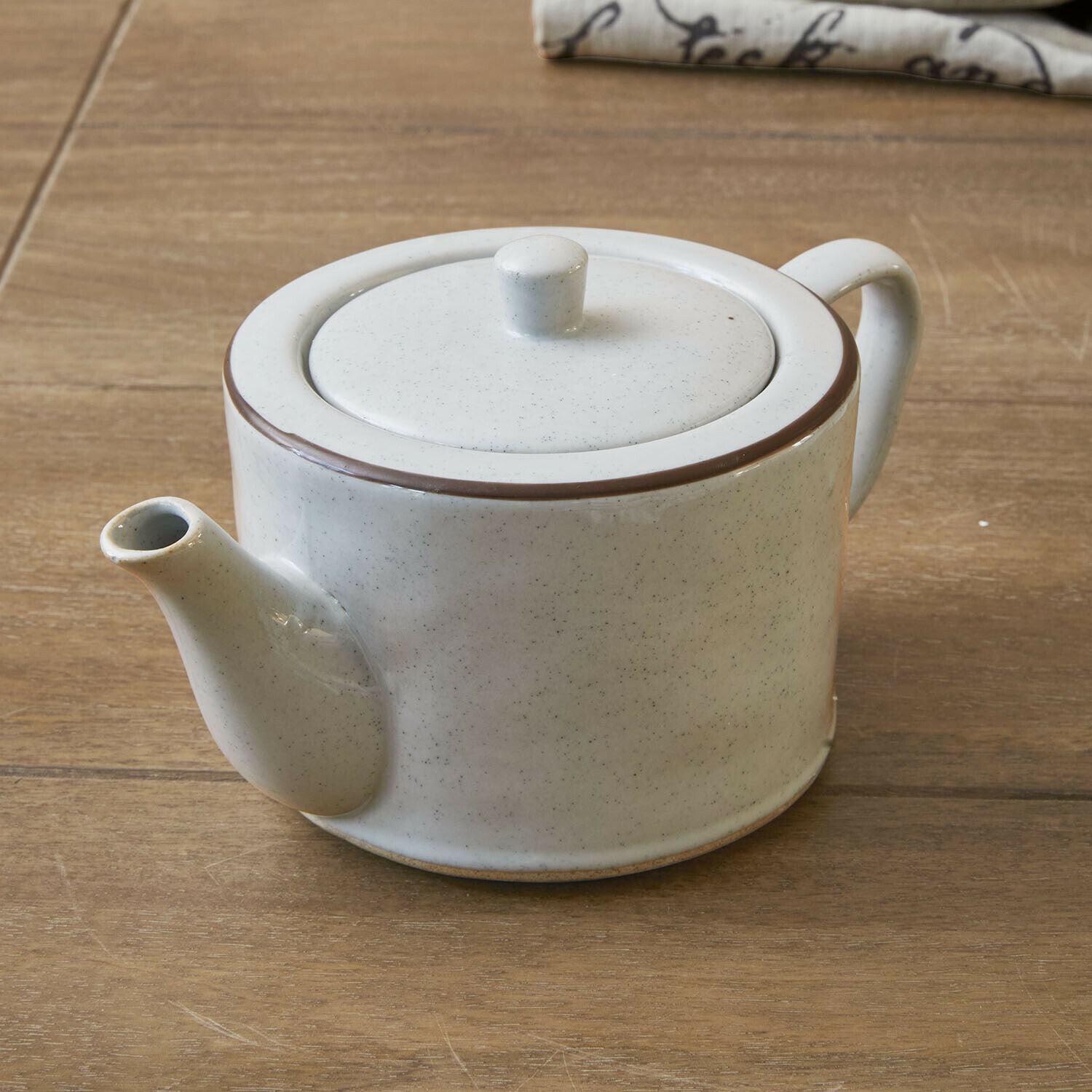Theepot Biarré Witte keramische theepot met bruine rand op houten tafel voor het zetten van thee