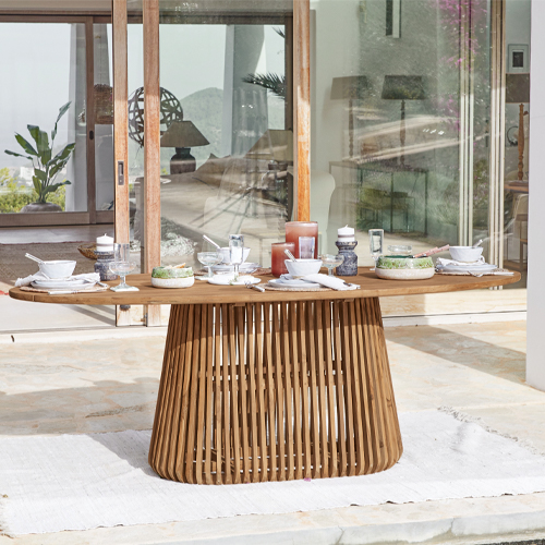 Ovale teakhouten tafel op terras met servies en decoraties, tuinmeubel