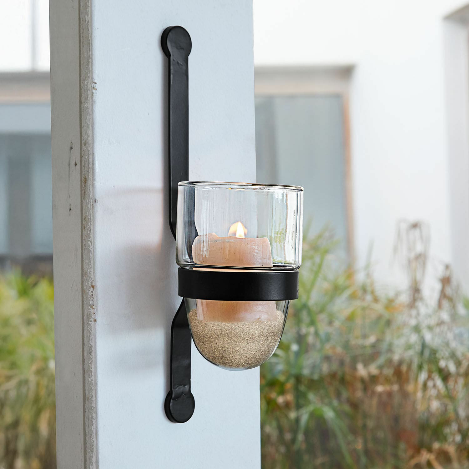 Wandkandelaar Astalis Zwarte metalen wandlamp met doorzichtige glazen kaarshouder en brandende decoratieve kaars