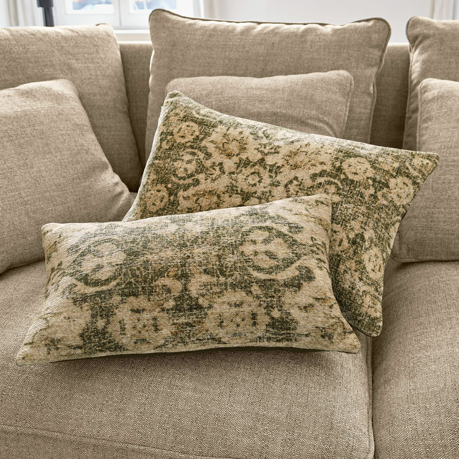 Kussenhoes set van 2 Calperino Twee decoratieve kussens met groen-beige patroon op beige stof op een bank