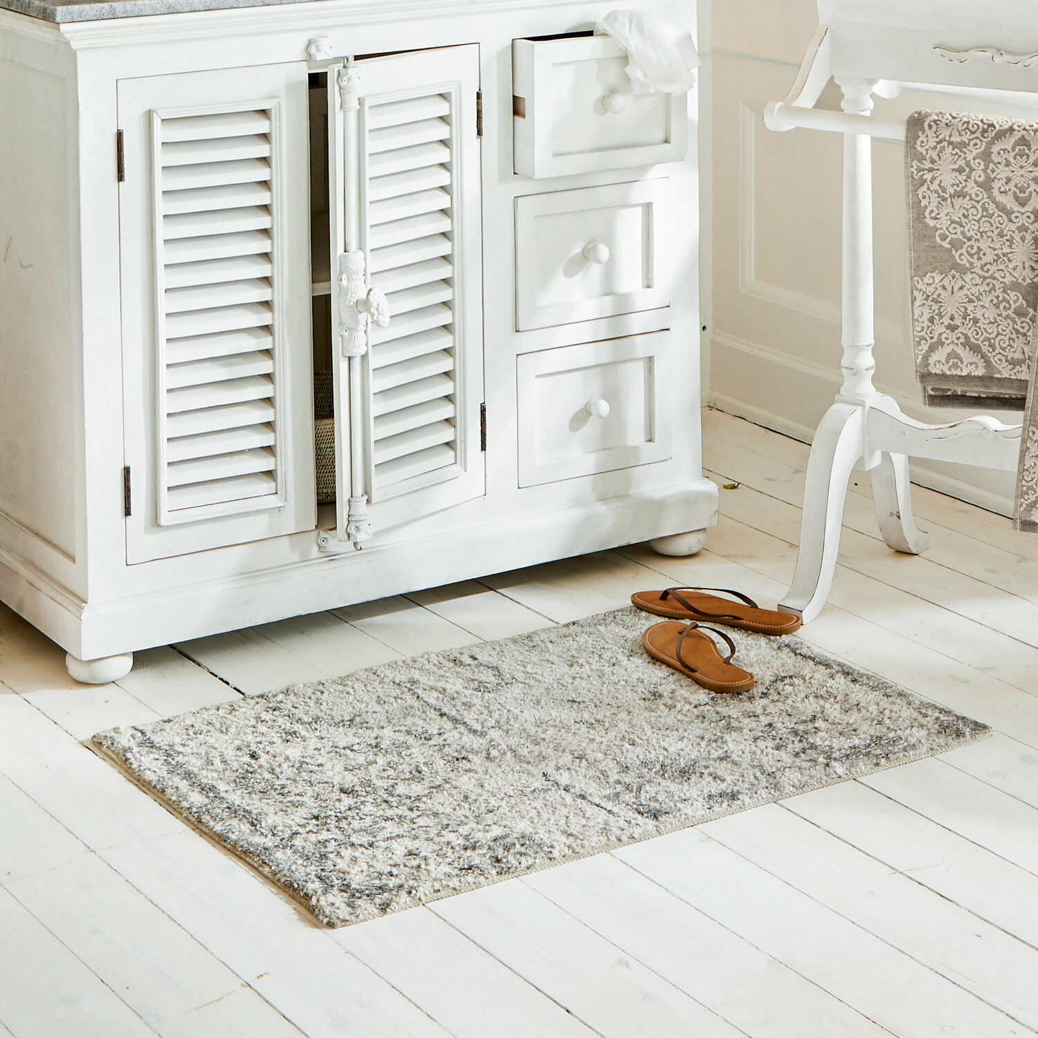 Badmat Veneur Grijs vloerkleed van zacht materiaal op witte houten vloer in lichte kamer