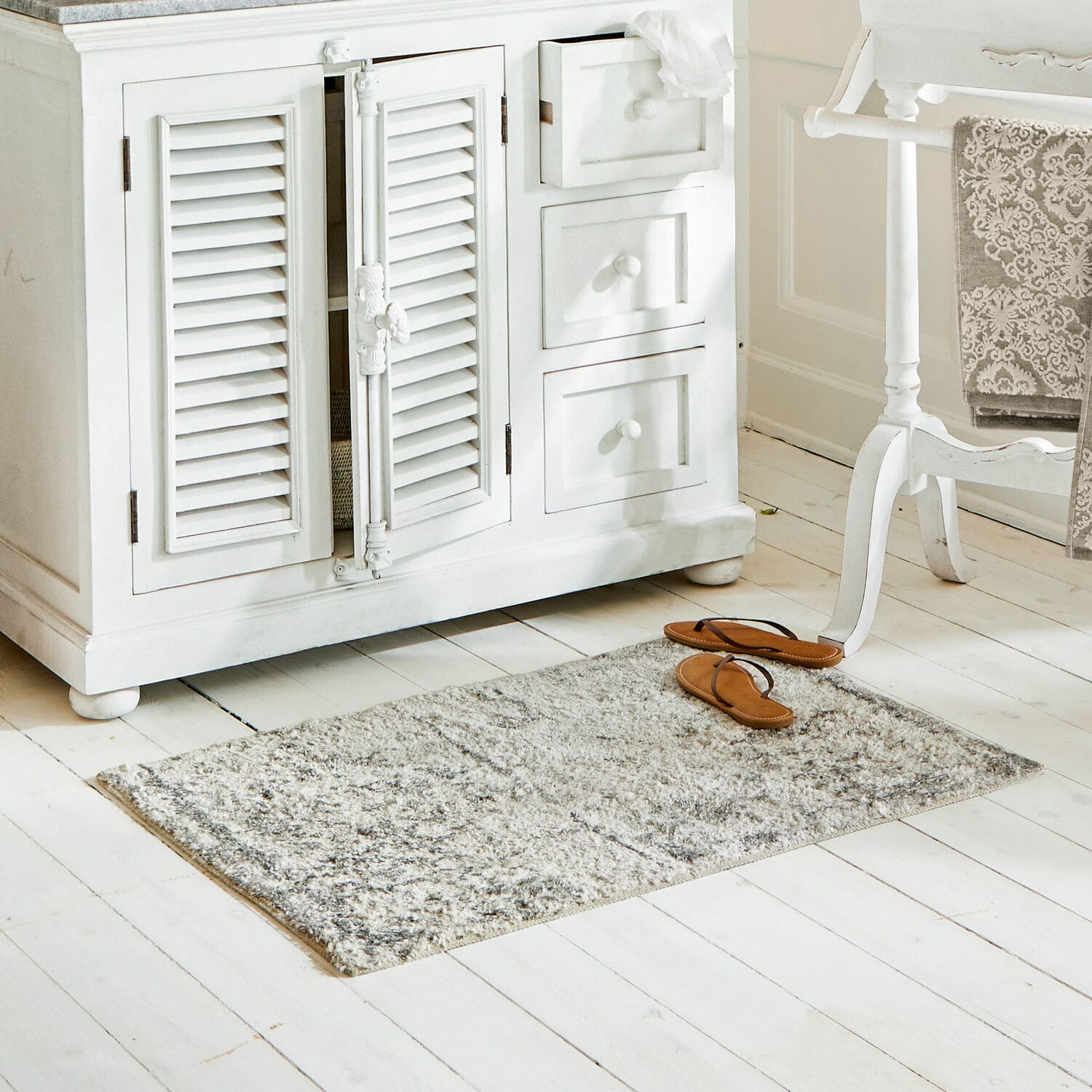 Badmat Veneur Grijs vloerkleed van zacht materiaal op witte houten vloer in lichte kamer
