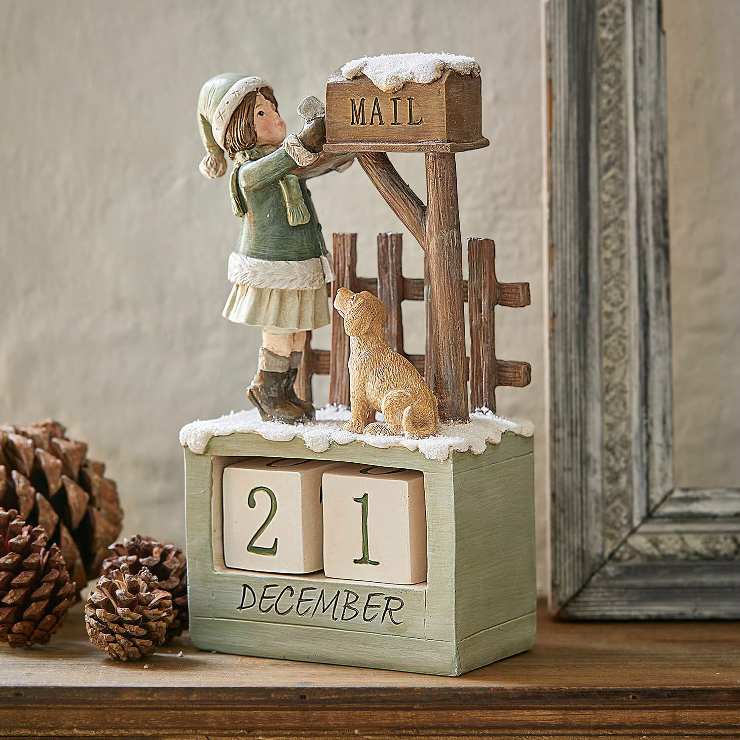 Houten adventskalender met meisje- en hondenfiguur bij besneeuwde brievenbus als winterdecoratie