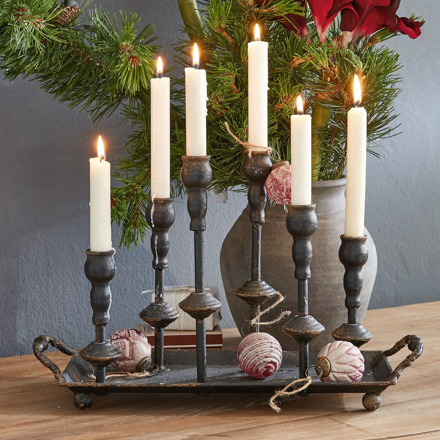 Kaarsenhouder Aisa Zwarte metalen kandelaar met zes witte kaarsen en kerstversiering op houten tafel