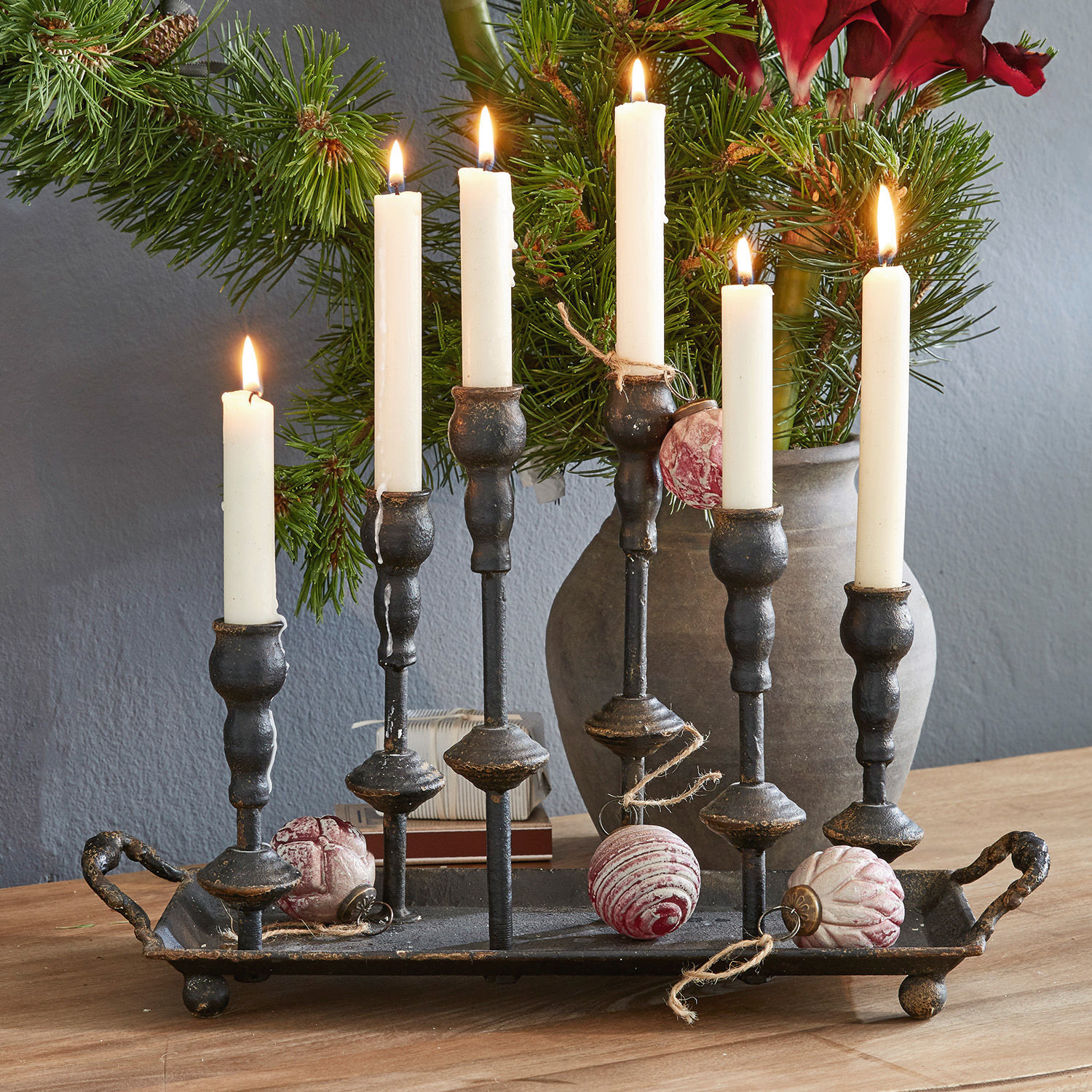 Kaarsenhouder Aisa Zwarte metalen kandelaar met zes witte kaarsen en kerstversiering op houten tafel