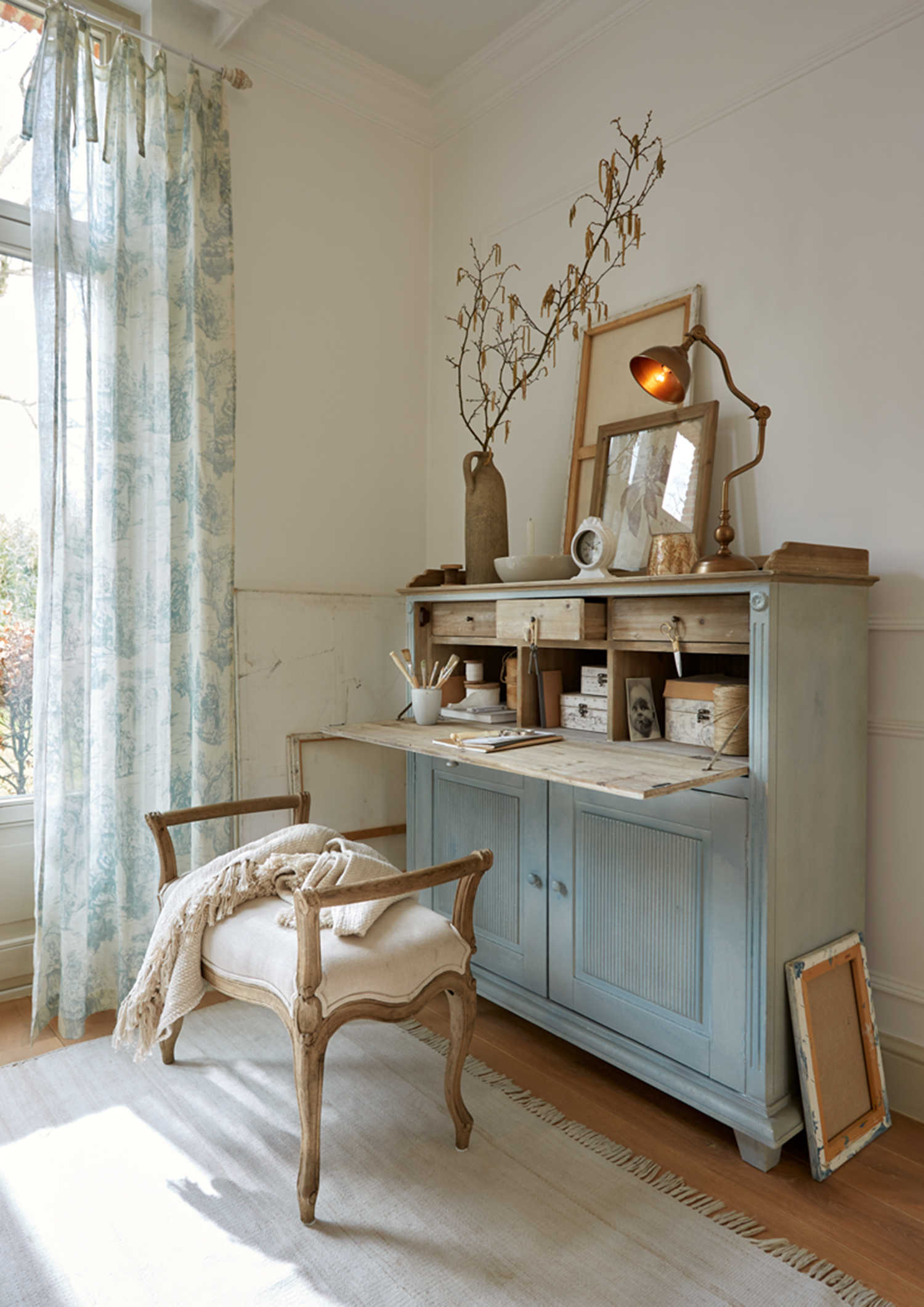Blauw houten dressoir met uitschuifbaar blad en decoraties in lichte, gezellige kamer