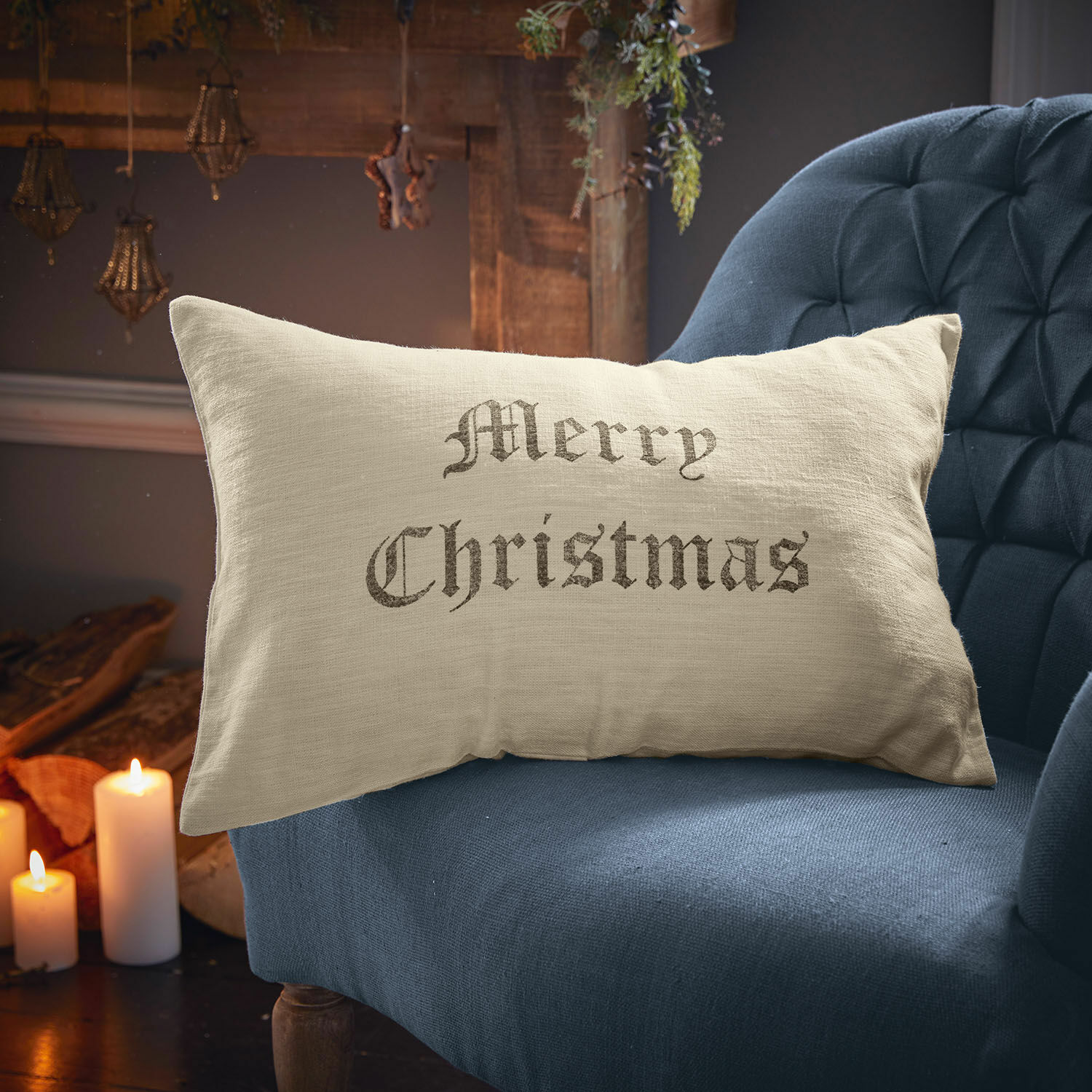 Beige linnen kussen met tekst Merry Christmas op blauwe stoel, kerstdecoratie