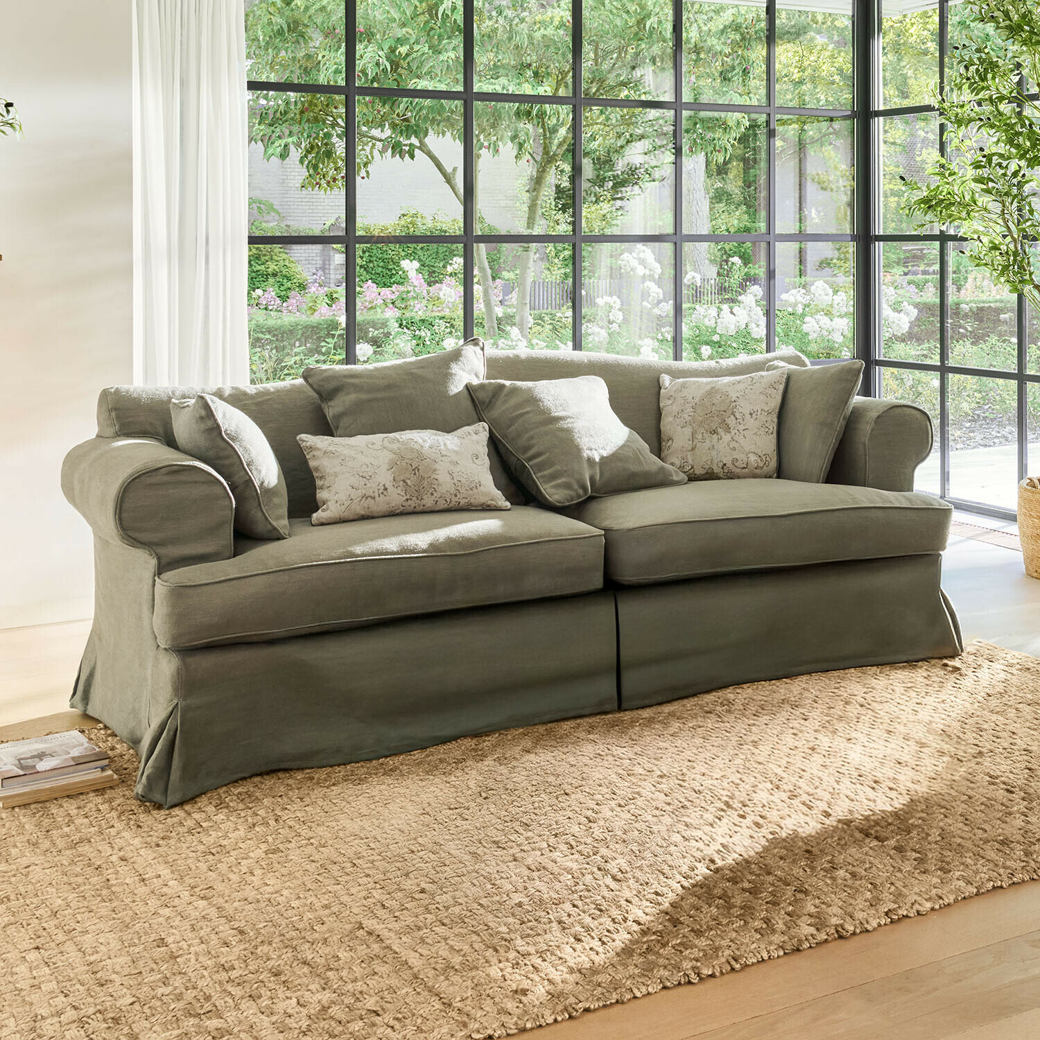 Grijze stoffen bank met sierkussens voor grote ramen met natuurlijk licht