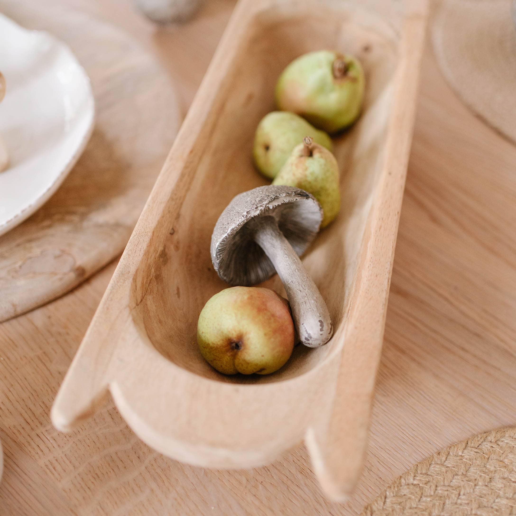 Houten schaal met decoratieve paddenstoel en groene peren voor herfsttafel