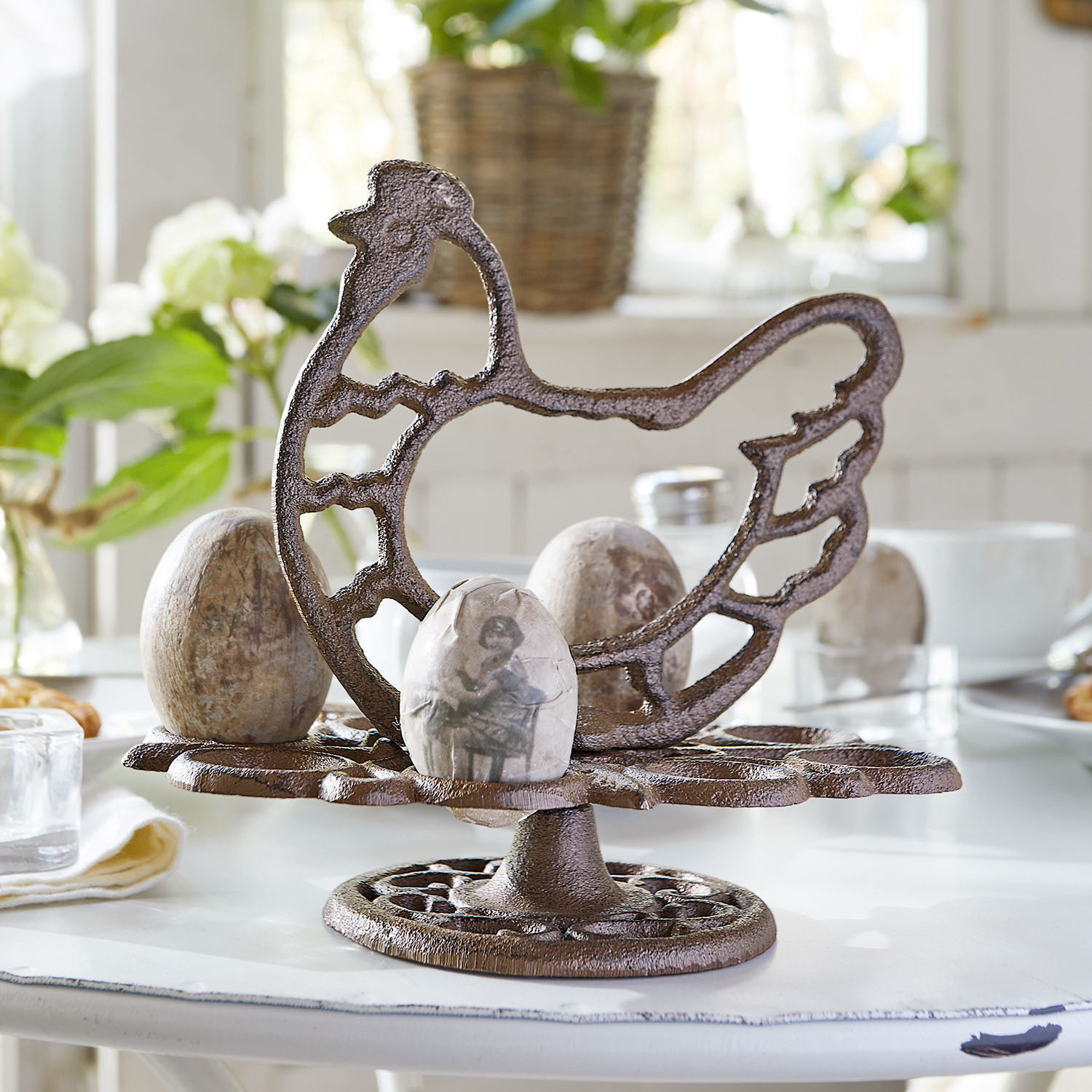 Etagère voor eieren Willa Bruine metalen eierhouder in kipvorm op witte tafel met decoratieve eieren