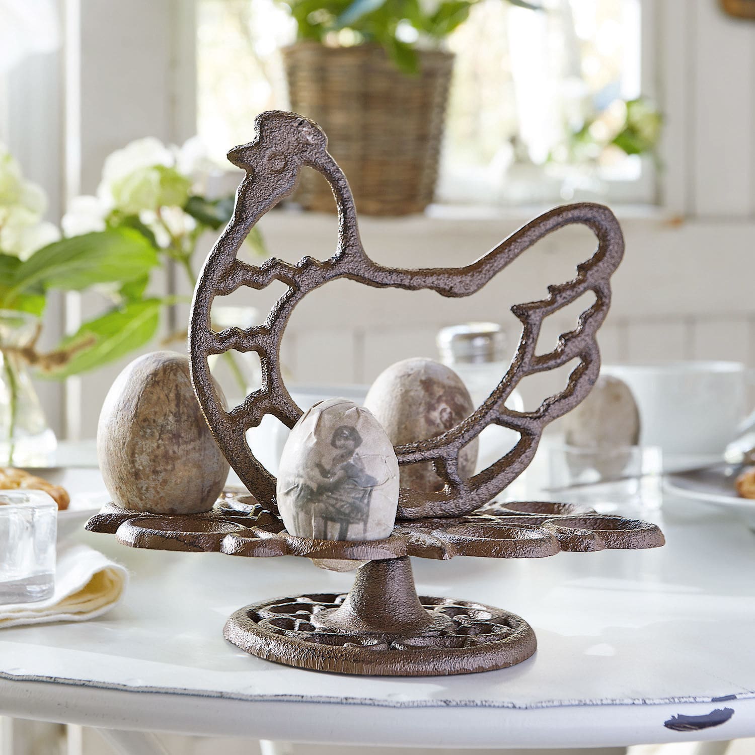 Etagère voor eieren Willa Bruine metalen eierhouder in kipvorm op witte tafel met decoratieve eieren