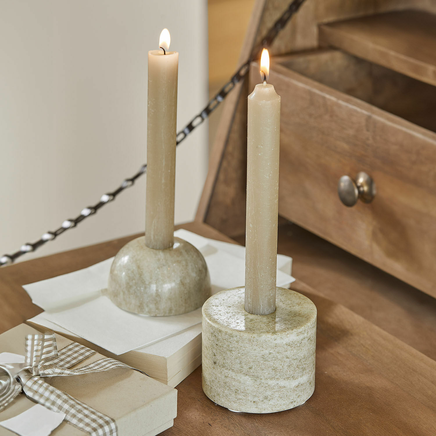 Kaarsenhouder set van 2 Najira Twee beige kaarsen in marmeren kandelaars op houten tafel, sfeervolle interieurdecoratie