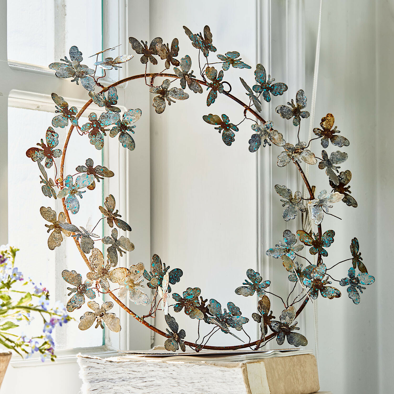 Decoratieve metalen krans met vlinders in roest- en turkoois tinten voor binnen- en buitendecoratie
