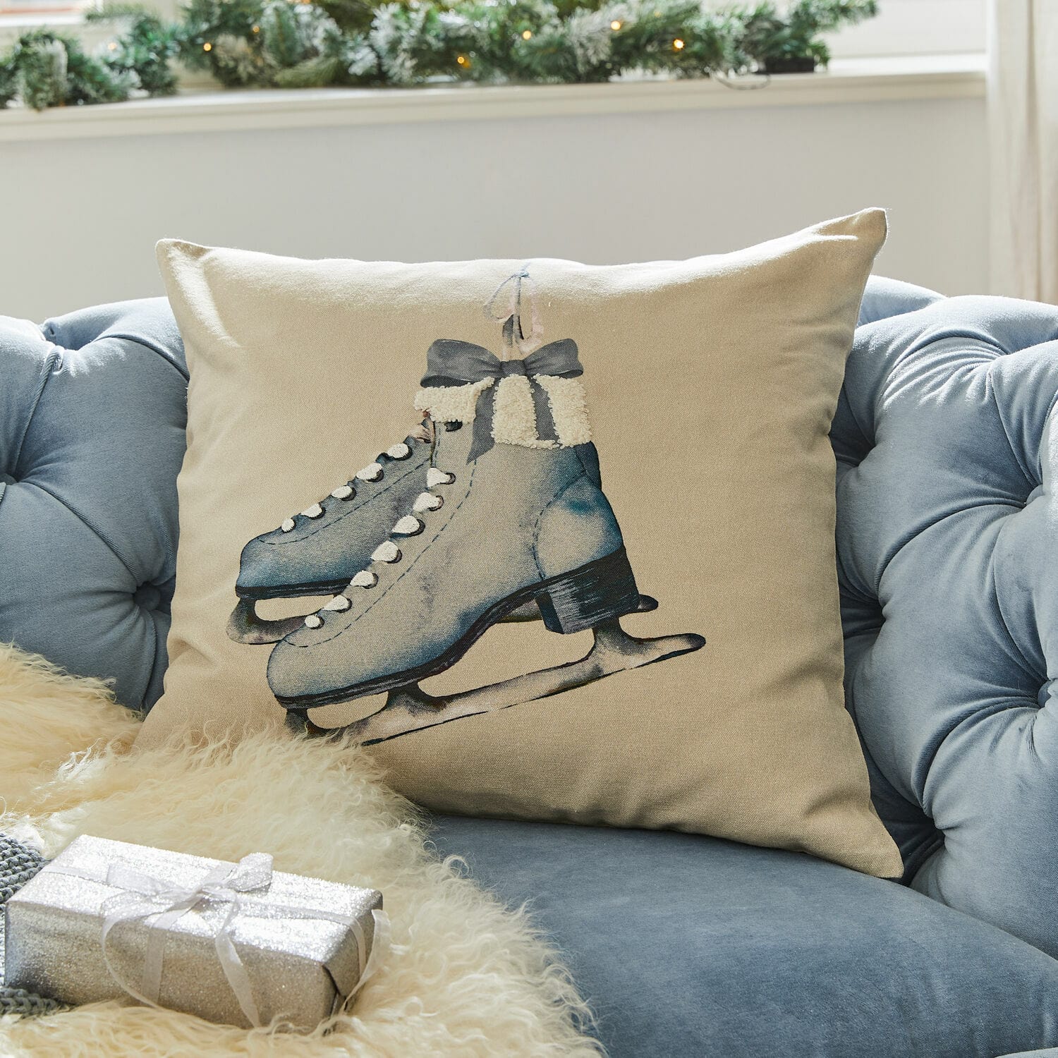 Kussenhoes Herveline Beige kussen met blauwe schaatsenprint op blauwe bank, winterse en feestelijke decoratie