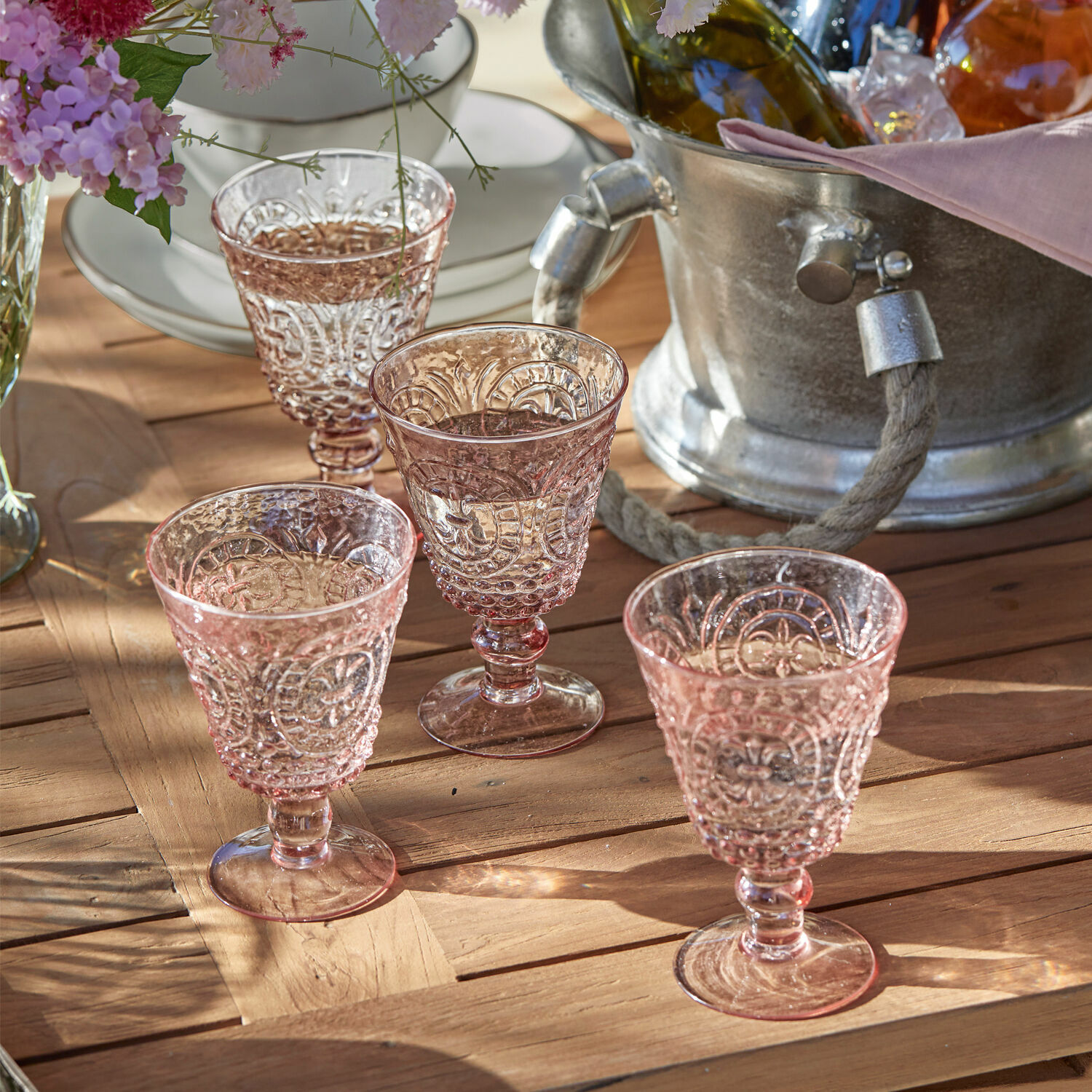 Wijnglas set van 4 Sarton Set van vier roze glazen met reliëf op houten tafel, stijlvolle tafeldecoratie