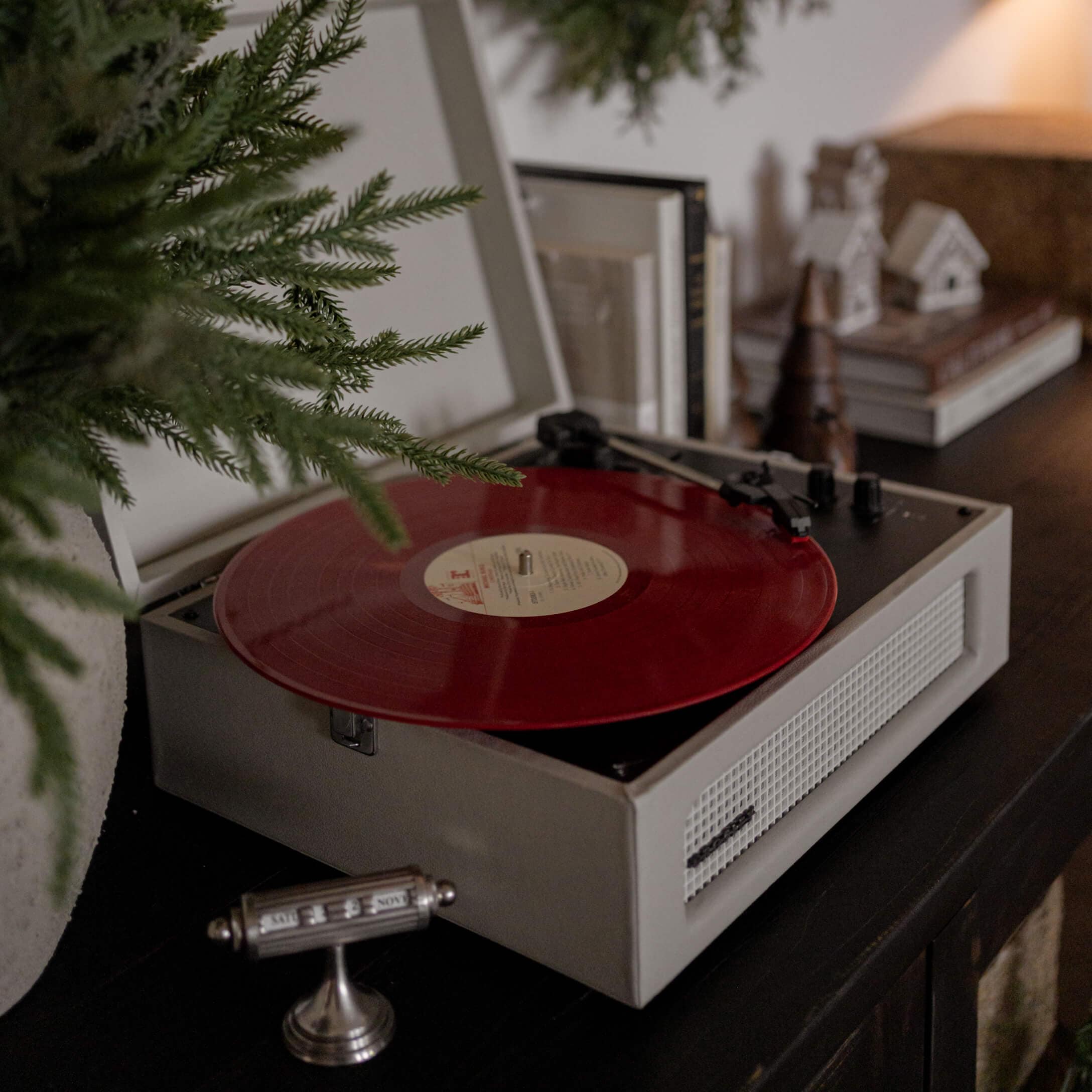 Retro platenspeler met rode vinylplaat op donkere kast in sfeervolle kamer