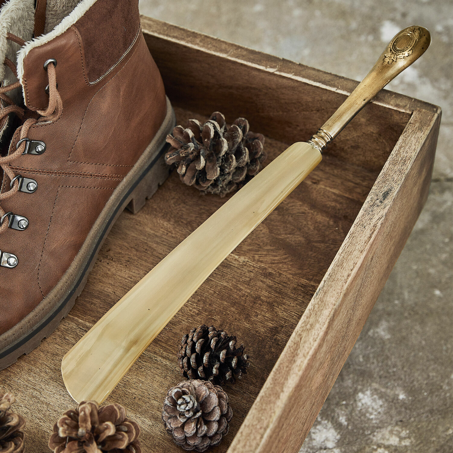 Schoenlepel Charles Elegante houten schoenlepel met messing handvat op houten dienblad naast bruine schoen