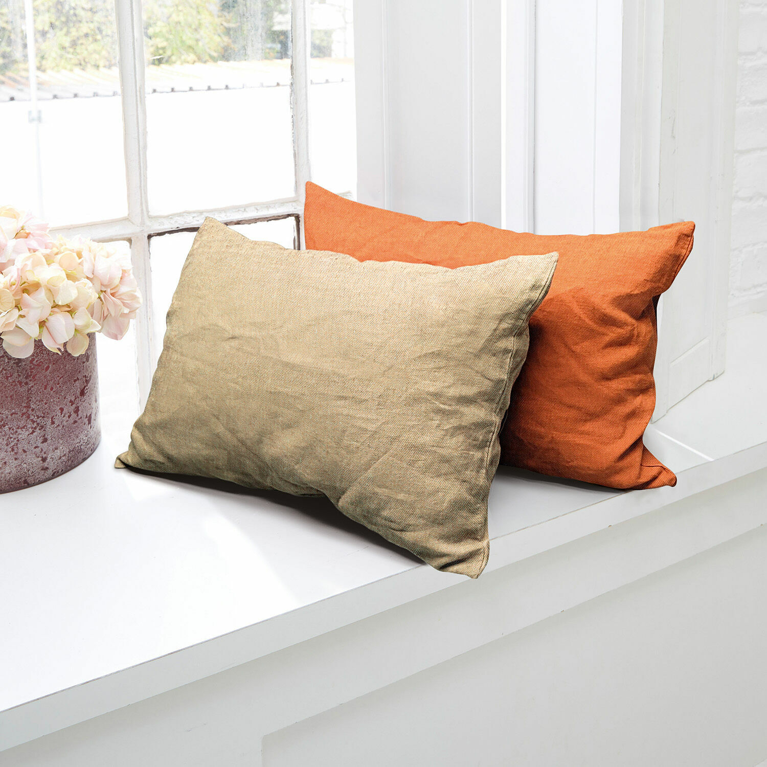 Kussenhoes set van 2 Balesta Twee decoratieve kussens van stof in beige en oranje op een wit vensterbank