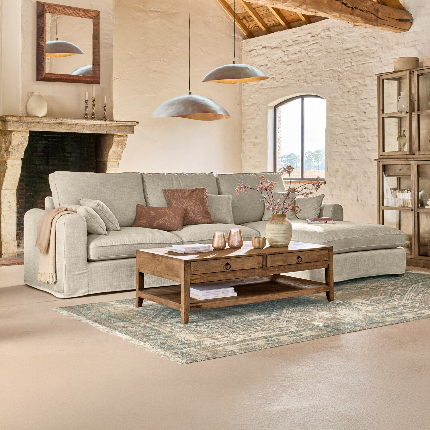 Gezellige woonkamer met beige stoffen hoekbank en houten salontafel op een patroon vloerkleed