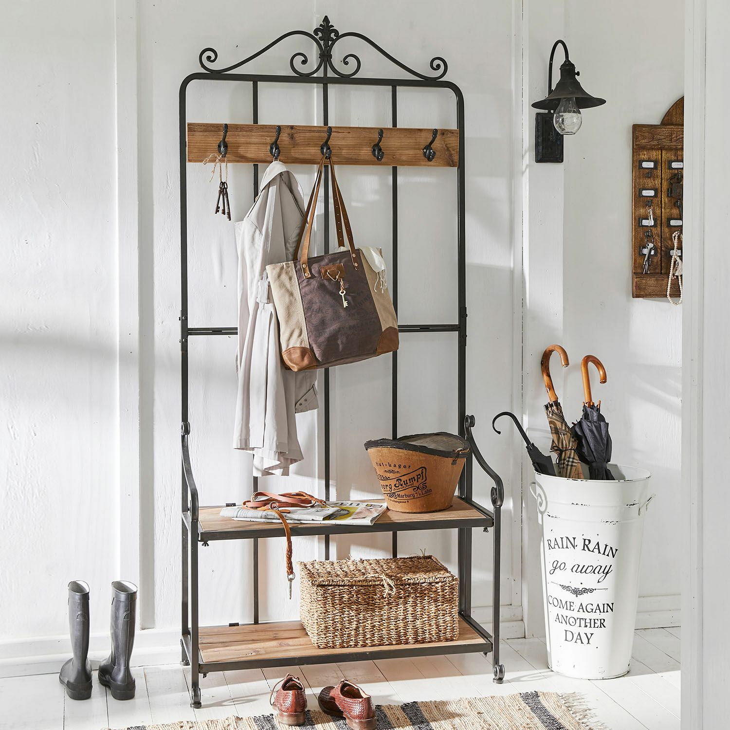 Zwarte metalen kapstok met houten planken en haken voor jassen en tassen in de hal