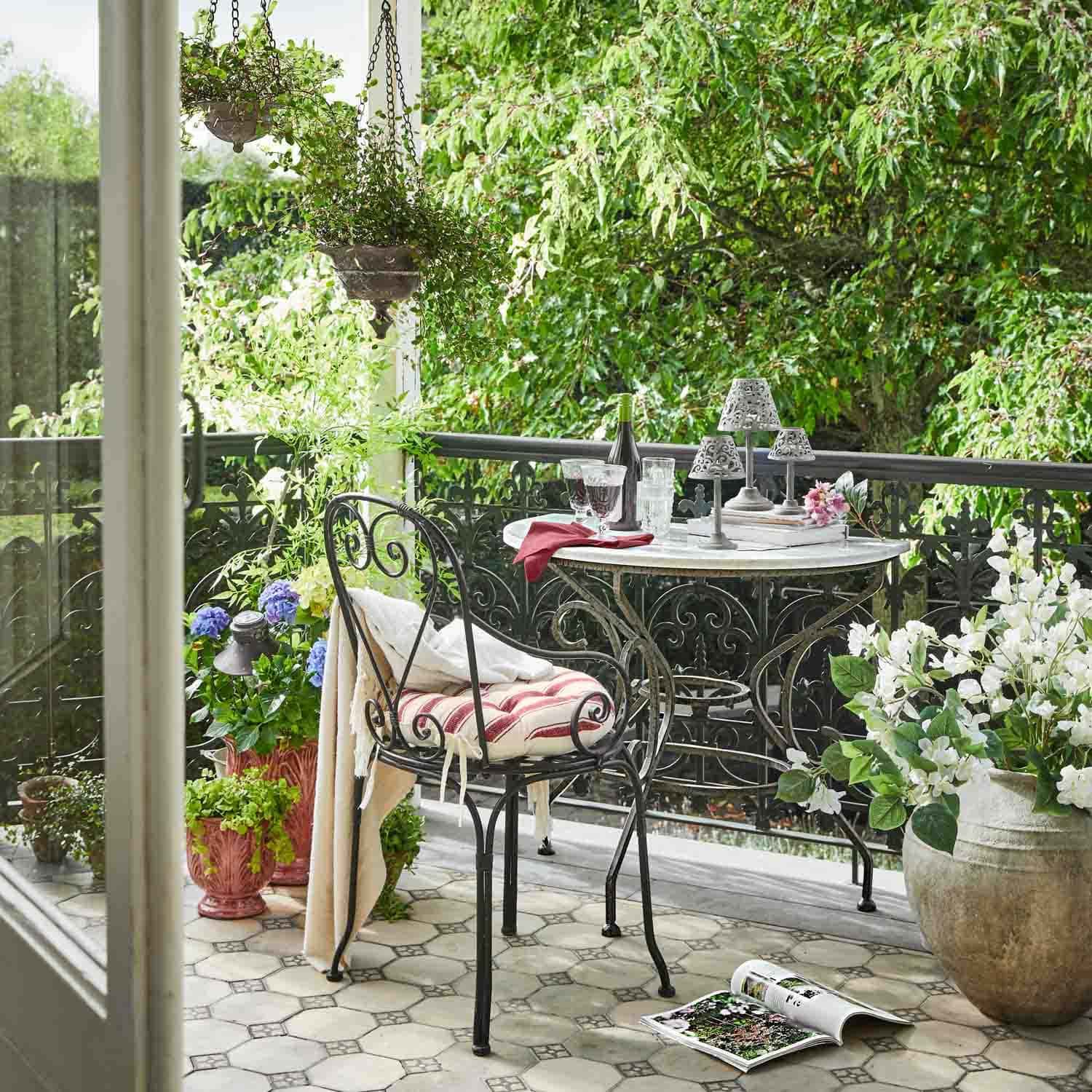 Balkon met metalen tafel en stoel, planten in potten, ontspannen buitenomgeving