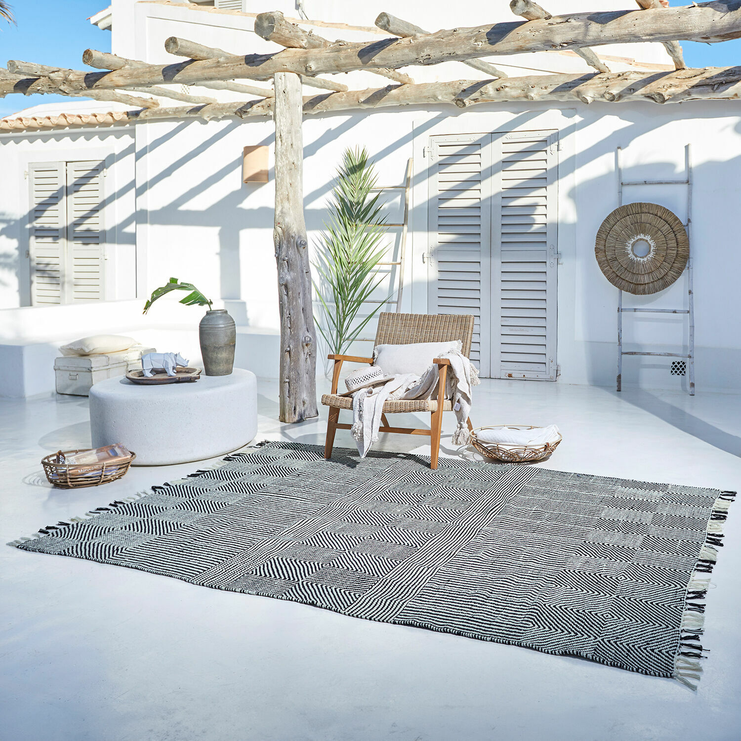 In- & outdoor vloerkleed Tamworth Katoenen vloerkleed met zwart-wit geometrisch patroon op lichte terrasvloer