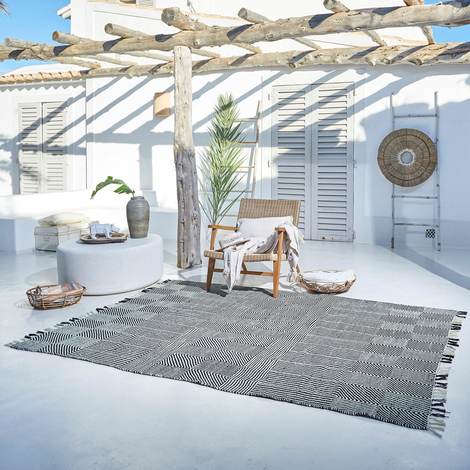 In- & outdoor vloerkleed Tamworth Katoenen vloerkleed met zwart-wit geometrisch patroon op lichte terrasvloer