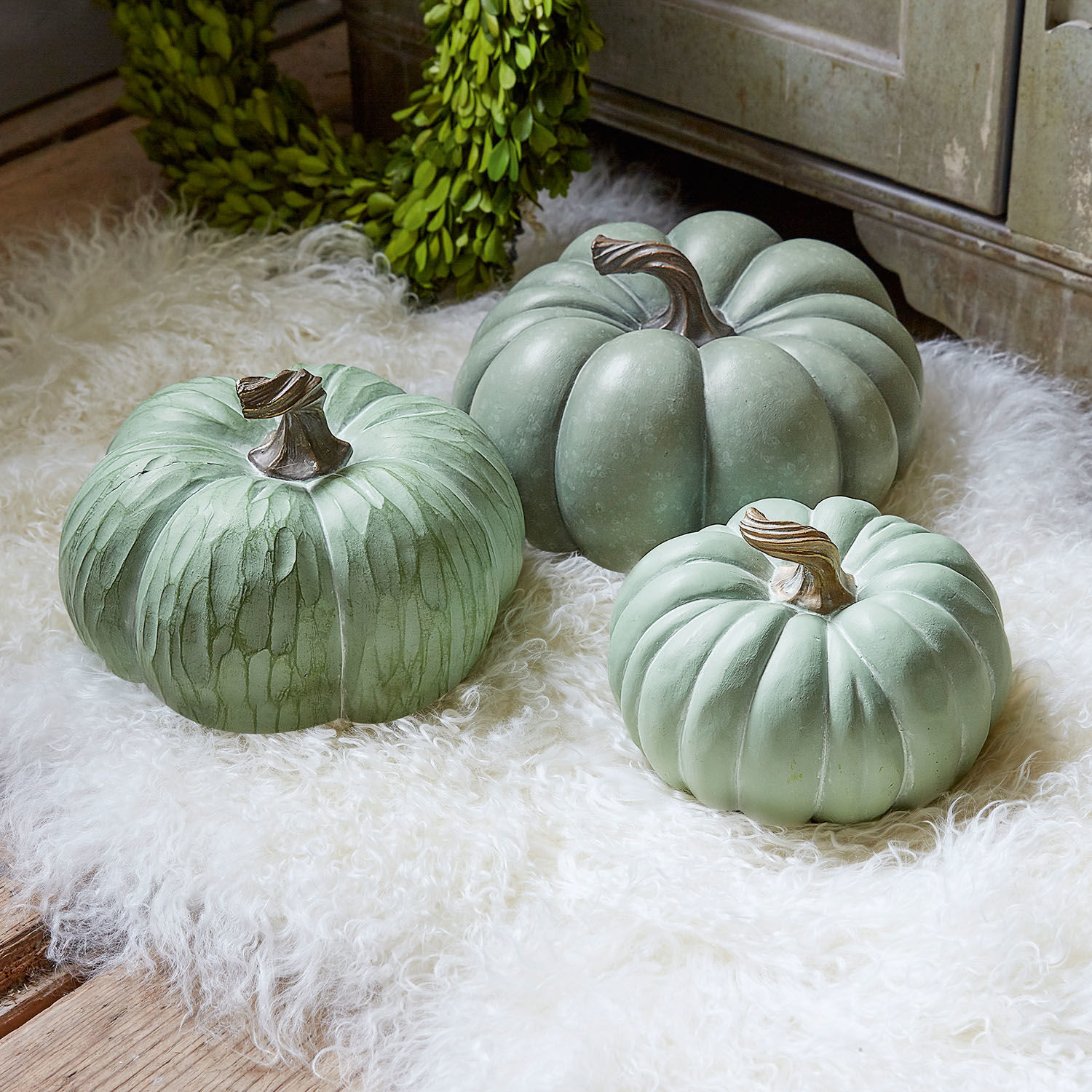 Pompoen set van 3 Villazon Drie decoratieve groene pompoenen op een wit bontkleed voor herfstdecoratie