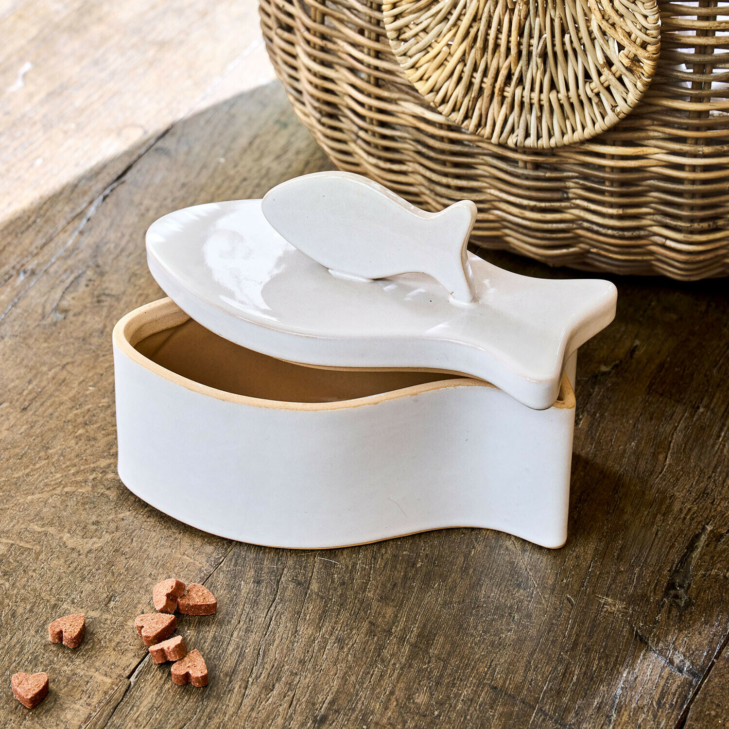 Witte keramische visvormige doos met deksel op houten tafel, decoratief en functioneel voor opslag