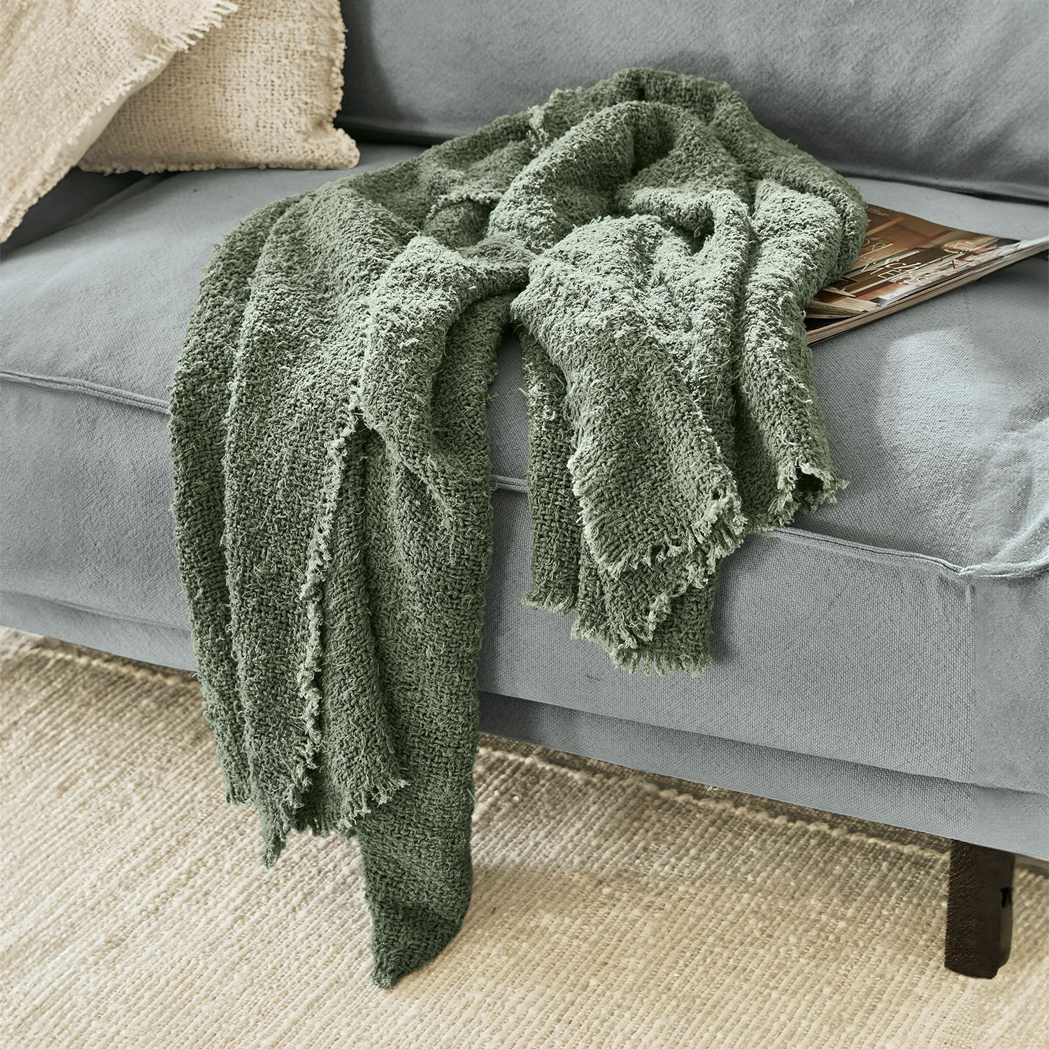 Plaid Juliana Zachte groene katoenen deken op grijze bank, decoratief en comfortabel woonaccessoire