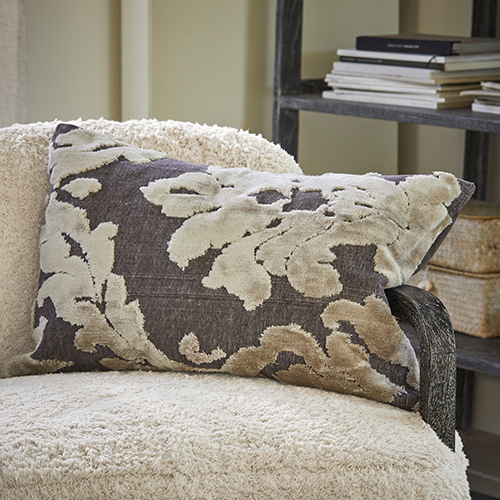 Decoratief kussen met beige bladmotief op grijze achtergrond op crèmekleurige stoel, woontextiel