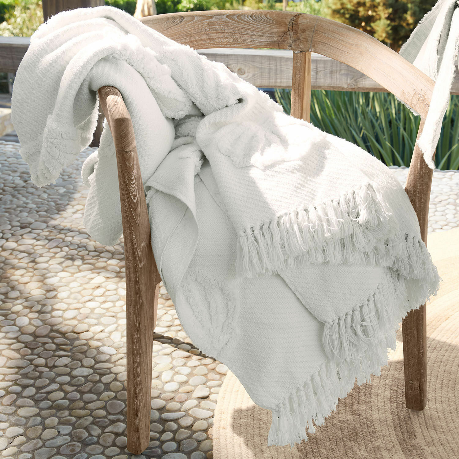 Witte katoenen deken met franjes op houten stoel, sfeervolle binnen- en buitendecoratie