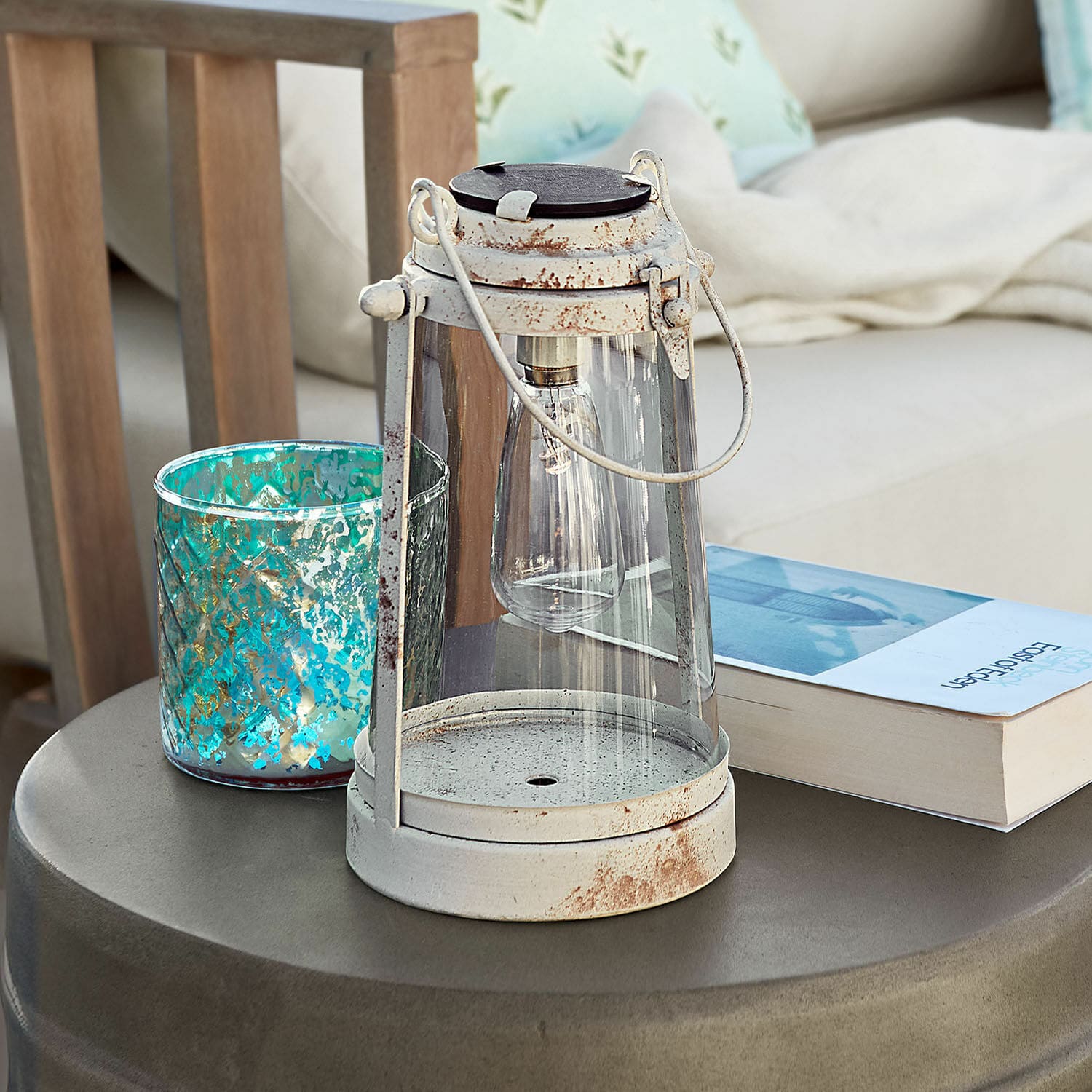 Witte metalen decoratieve lantaarn met verouderd effect op moderne tuintafel