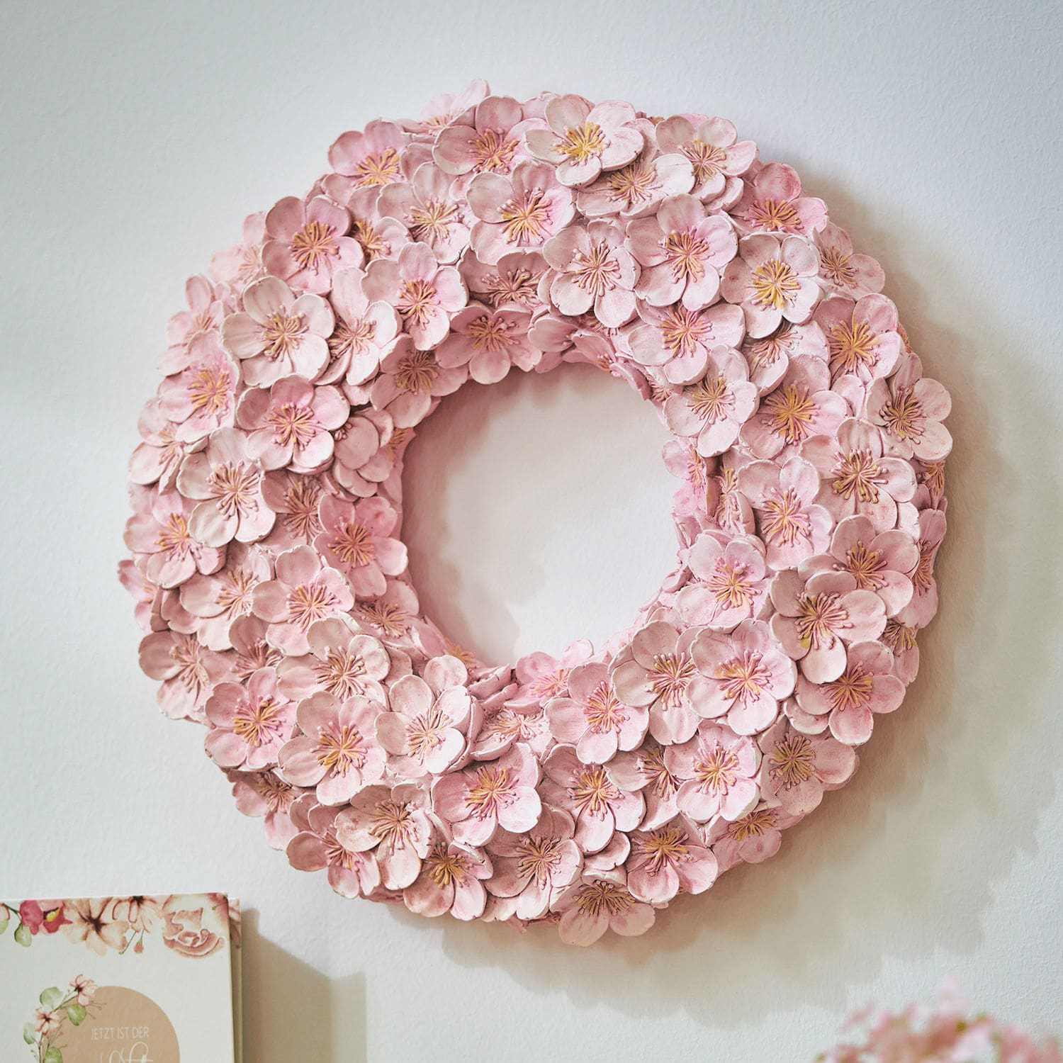 Krans Garlan Decoratieve wandkrans van roze stoffen bloemen, stijlvolle woondecoratie.